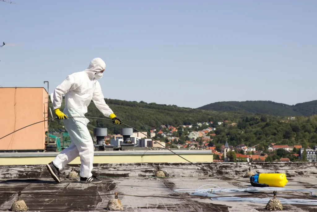 Technik v ochrannom obleku pracuje na streche bytového domu